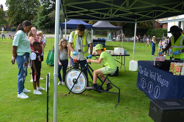 child on a smoothie bike next to the eat well wagon