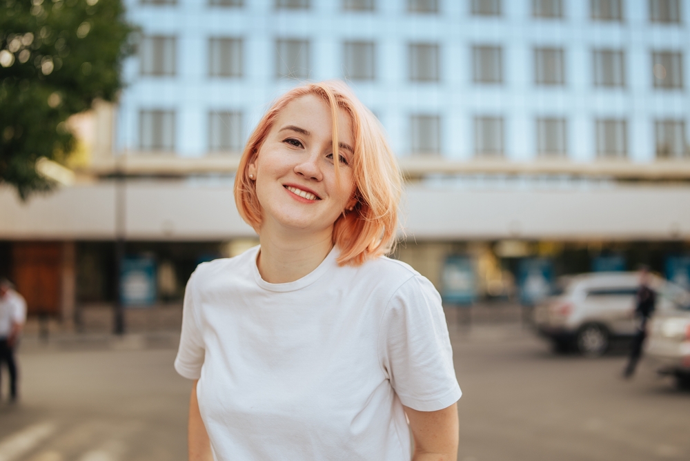 Teenage girl smiling standing in front of a multi-level building