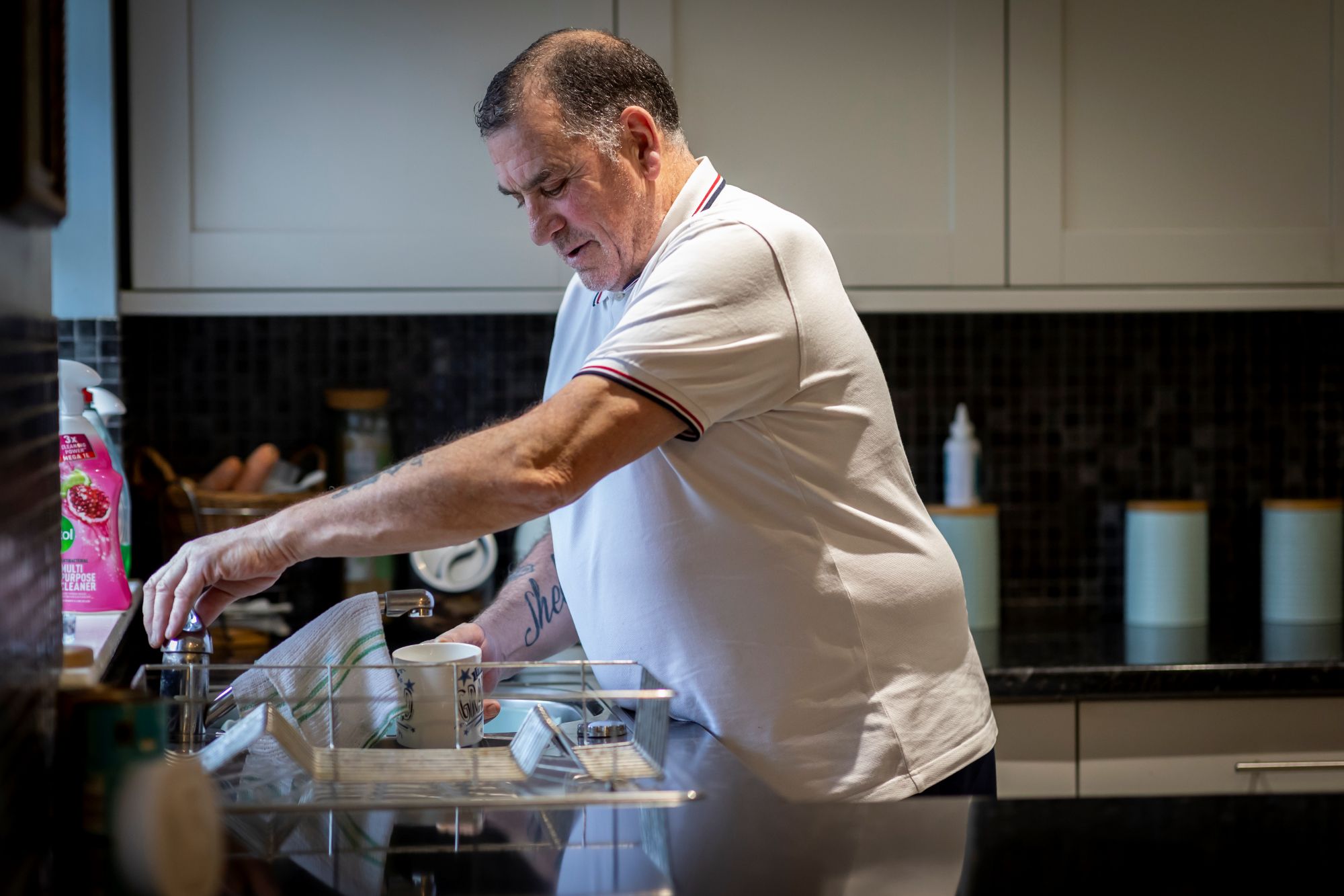 Man washing cups in a kitchen sink