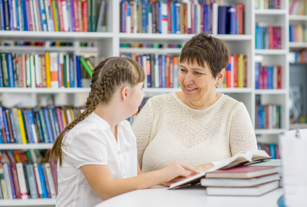 Girl and librarian reading in library