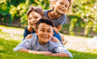 smiling children lie on grass