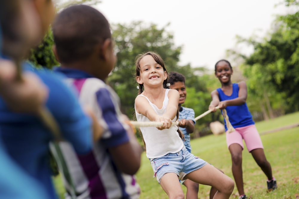 children playing tug of war outside