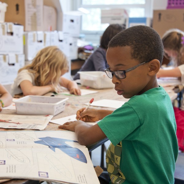 a young boy writing in a book