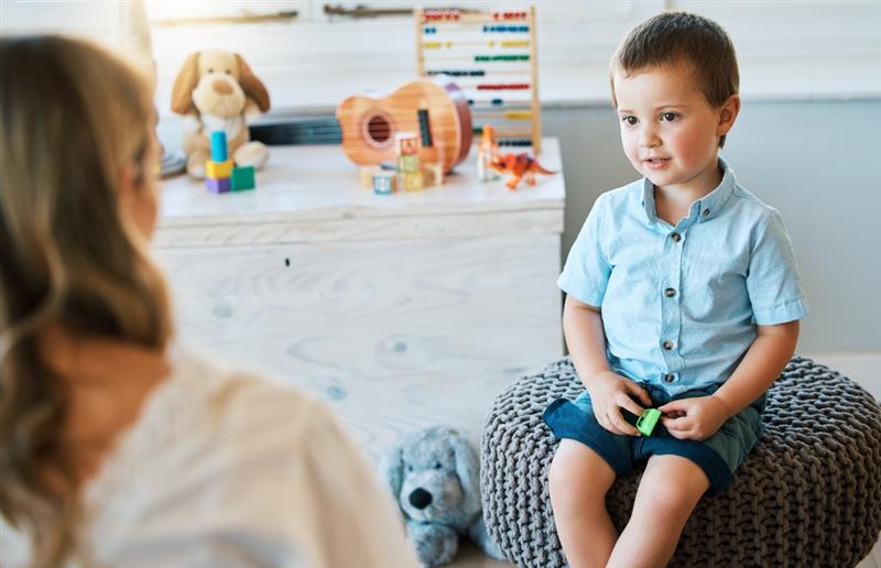 Child, psychology and woman talking for therapy consultation, development evaluation and health progress review. Boy, psychologist and check-up for autism counselling, learning support and assessment 