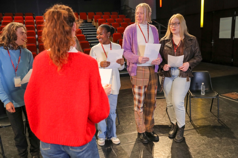 Six young people rehearsing in a performance space