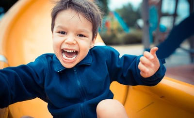 Boy Smiling At Bottom Of Slide