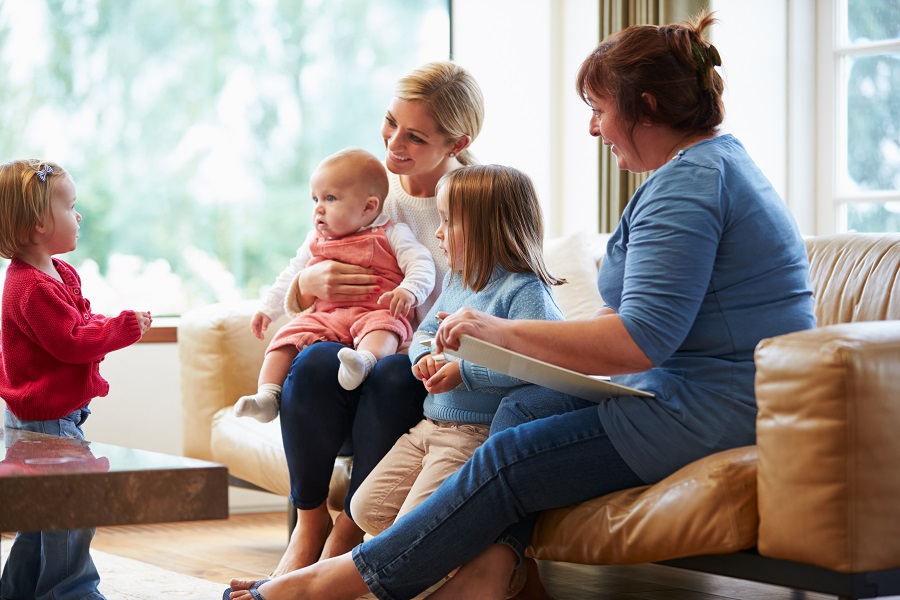 A Family Sit With A Social Worker And All Look At One Child Talking