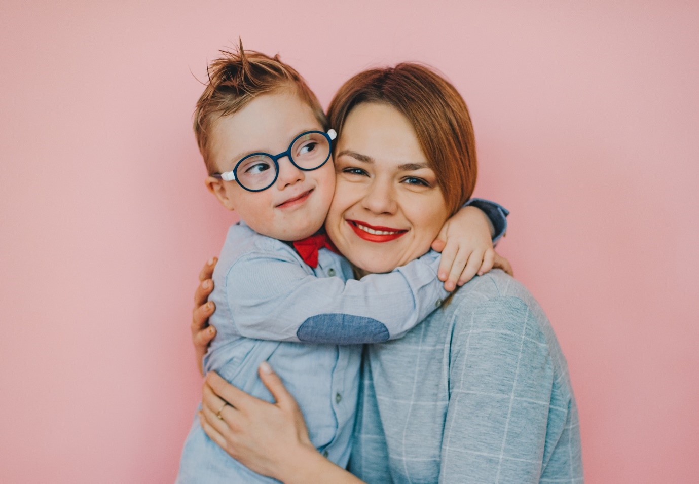 A child and a woman embracing and smiling