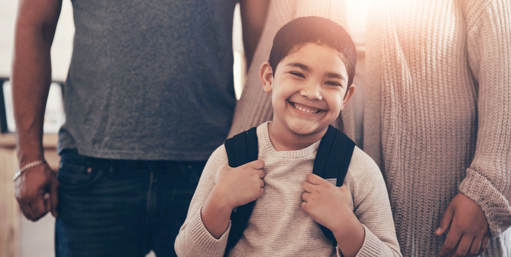 Backpack, portrait and smile of boy with parents in home for back to school, education or learning. 